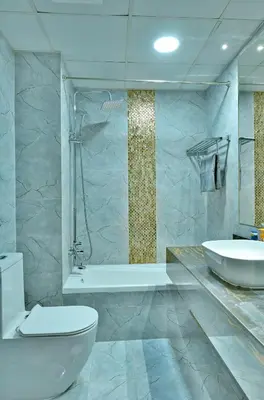 a bathroom with a tub and a toilet and a sink at Luxestay Holiday Homes in Dubai