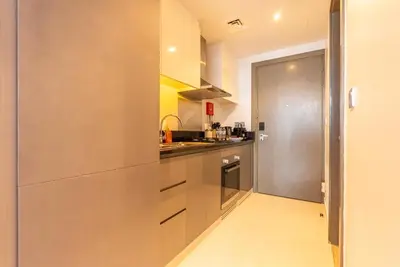 a kitchen with a large stainless steel refrigerator at Luxury Waterfront Studio - Stunning Canal Views in Damac Maison Prive in Dubai