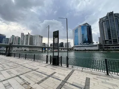 a bridge over a river in a city with buildings at Luxury Waterfront Studio - Stunning Canal Views in Damac Maison Prive in Dubai