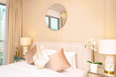 a bedroom with a white bed with a mirror at Elite Royal Apartment - Sky Series - Panoramic New Fountain & Burj Khalifa View - Nebuchadnezzar II in Dubai