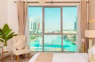 a bedroom with a large window with a view of a pool at Elite Royal Apartment - Sky Series - Panoramic New Fountain & Burj Khalifa View - Nebuchadnezzar II in Dubai