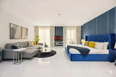 a bedroom with a blue bed and a couch at Ahlan Marhaba Marina JBR in Dubai