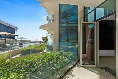 an open glass door to a building with a garden at Stylish Missoni Studio with Direct Pool Access in Dubai