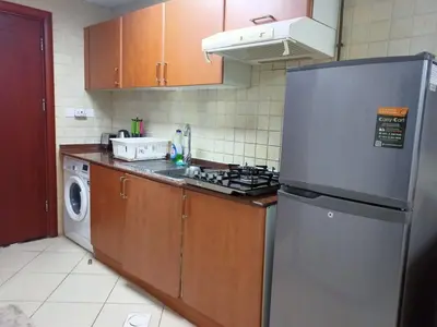 a kitchen with a refrigerator and a washer and dryer at Dubai Marina Studio in Dubai