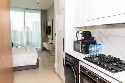 a kitchen with a washing machine in a room at Modern Studio Apartment - Binghatti Azure 633 in Dubai