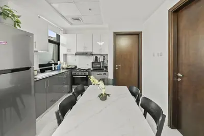 a kitchen with a table with black chairs and a white table sidx sidx at Apartment-Private Bathroom in Dubai