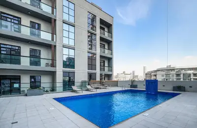 a swimming pool in front of a building at Apartment-Private Bathroom in Dubai