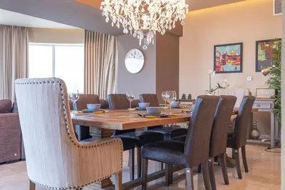 a dining room table with chairs and a chandelier at StayShort - Majestic 4BR in Dubai Marina - Sleeps 8 in Dubai