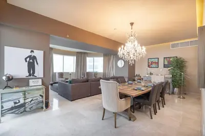 a dining room and living room with a dining table at StayShort - Majestic 4BR in Dubai Marina - Sleeps 8 in Dubai