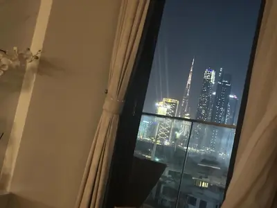 a window with a view of a city at night at Burj Khalifa View Ideal for Families in Dubai