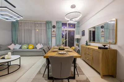 a kitchen and living room with a table and a couch at 3-Bedroom Cozy Townhouse with great amenities in Dubai in Dubai