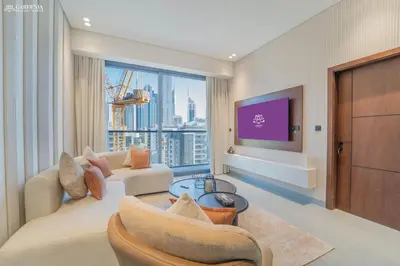 a living room with a couch and a tv at Near Museum of the Future - Homey Apartment-Jumeirah Garden in Dubai