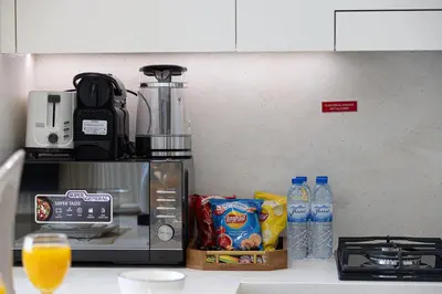 a kitchen counter with a microwave and some food and drinks at Luxury Binghatti Phantom Suites By Hostiva in Dubai