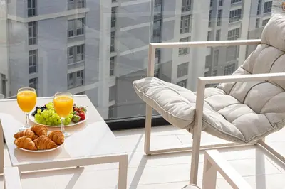 a table with a bowl of fruit and two glasses of orange juice at Luxury Binghatti Phantom Suites By Hostiva in Dubai