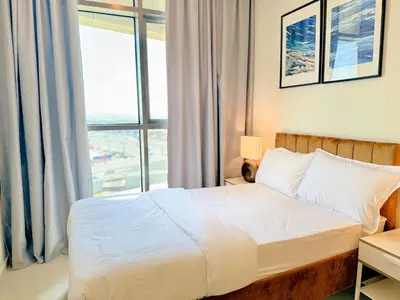 a bedroom with a bed and a large window at Cozy 2BHK - Sea View in Dubai