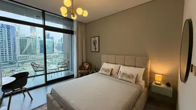 a bedroom with a bed and a large window at Stylish Studio Apartment in Peninsula 1 in Dubai