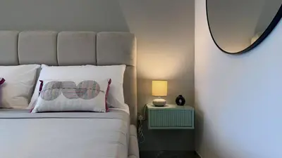a bedroom with a bed with a pillow and a mirror at Stylish Studio Apartment in Peninsula 1 in Dubai