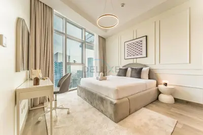 a bedroom with a bed and a desk and a window at Burj Khalifa View, Easy Access to Dubai Mall and Burj Khalifa - Imperial Avenue, Downtown Dubai by Deluxe Holiday Homes in Dubai