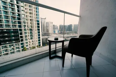 a chair and a table in front of a window at Luxury Studio at PRIVE by DAMAC - Canal Views in Dubai