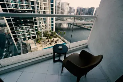 a room with a chair and a window with a view at Luxury Studio at PRIVE by DAMAC - Canal Views in Dubai