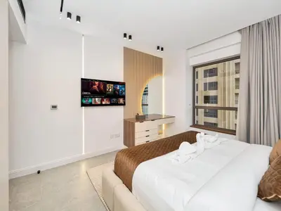 a bedroom with a large bed and a tv at 4 BHK JBR BEACHFRONT# Next to Dubai Eye# Marina View in Dubai