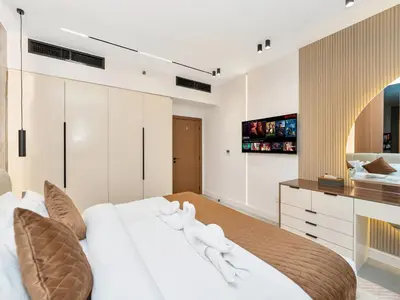 a bedroom with a large white bed and a television at 4 BHK JBR BEACHFRONT# Next to Dubai Eye# Marina View in Dubai