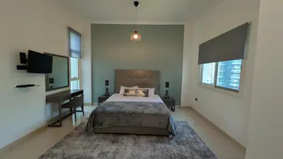 a bedroom with a bed and a desk in it at Superb Marina Views, Entire 1BR Apartment - Atlantic Towers next to Marina Mall in Dubai