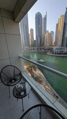 a balcony with two tables and a view of a city at Superb Marina Views, Entire 1BR Apartment - Atlantic Towers next to Marina Mall in Dubai