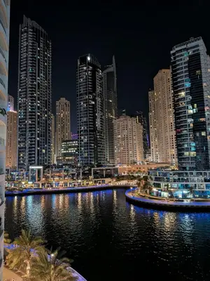 a city skyline at night with a river and buildings at Superb Marina Views, Entire 1BR Apartment - Atlantic Towers next to Marina Mall in Dubai