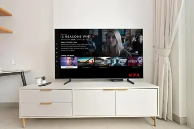 a flat screen tv sitting on top of a white cabinet at Socio Tower Apt - Parking, Balcony&Pool - by Rentujemy in Dubai