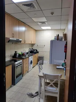 a kitchen with a table and a white refrigerator at Spacious Master Bedroom with Balcony Horizon Tower, Dubai Marina in Dubai