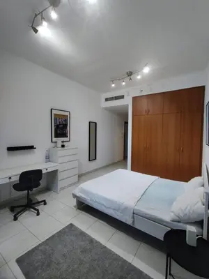 a bedroom with a bed and a desk and a computer at Spacious Master Bedroom with Balcony Horizon Tower, Dubai Marina in Dubai