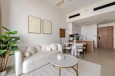 a living room with a couch and a table at Cozy and Stylish 1BR in JVC in Dubai