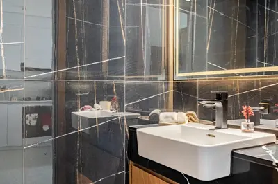 a bathroom with a white sink and a mirror at Cozy and Stylish 1BR in JVC in Dubai