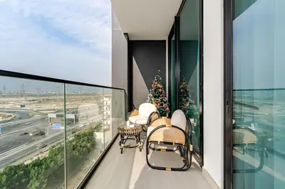 a balcony with chairs and a christmas tree on it at Cozy and Stylish 1BR in JVC in Dubai