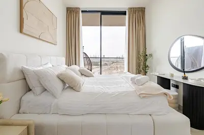 a white bed in a room with a window at Cozy and Stylish 1BR in JVC in Dubai
