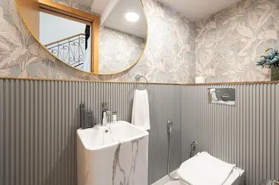 a bathroom with a sink and a mirror and a toilet at Palm Jumeirah Luxury Villa 4BR Private BeachAccess in Dubai