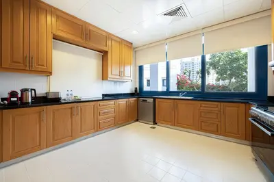 a large kitchen with wooden cabinets and a window at Palm Jumeirah Luxury Villa 4BR Private BeachAccess in Dubai