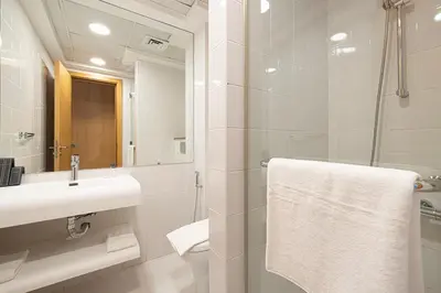 a bathroom with a sink and a shower with a mirror at Palm Jumeirah Luxury Villa 4BR Private BeachAccess in Dubai