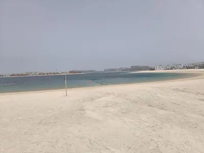 a beach with a stick in the sand and water at Palm Jumeirah Luxury Villa 4BR Private BeachAccess in Dubai