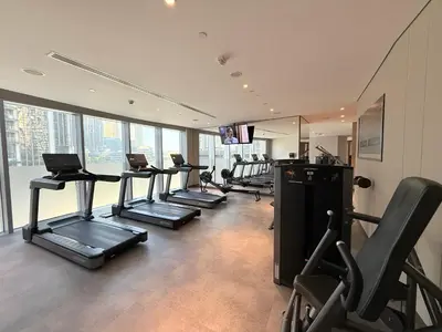 a gym with a row of treadmills and machines at Urban Luxury Burj Vista Apartments Direct Burj Khalifa View in Dubai
