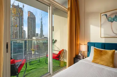 a bedroom with a window with a view of a city at Fireworks Burj Khalifa View - One bedroom Apartment in Dubai