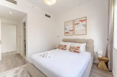 a white bedroom with a large white bed in it at HAVN - 3 Bedroom in Downtown, Burj Khalifa View in Dubai