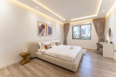 a bedroom with a bed and a couch at HAVN - 3 Bedroom in Downtown, Burj Khalifa View in Dubai