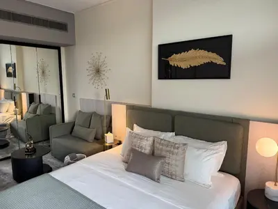 a bedroom with a bed and a living room at MAG 318 Luxury Studio Resort Style Amenities in Dubai