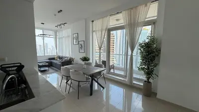 a living room with a table and chairs and a couch at Stunning 1-Bedroom Apartment in Botanica Tower in Dubai