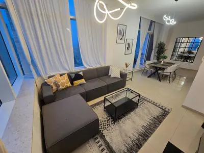 a living room with a couch and a table at Stunning 1-Bedroom Apartment in Botanica Tower in Dubai