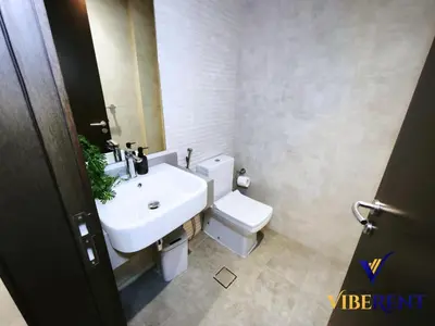 a bathroom with a white sink and a toilet at 2BHK near Expo, Al Maktoum Airport, Rooftop Pool in Dubai