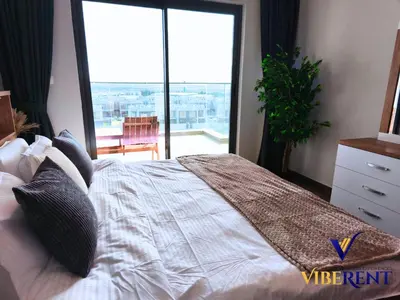 a bedroom with a large bed with a large window at 2BHK near Expo, Al Maktoum Airport, Rooftop Pool in Dubai