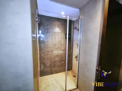 a shower with a glass door in a bathroom at 2BHK near Expo, Al Maktoum Airport, Rooftop Pool in Dubai
